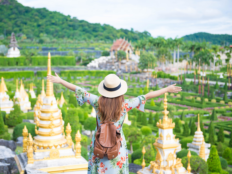 Nong Nooch bahçesinde sırtı dönük kollarını açan turist