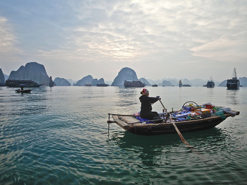Vietnam halong körfezinde tekne ile satış yapan yerli kadın