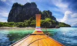 Denizde sadece önü görünen tekne ve karşısında kayalık Phuket